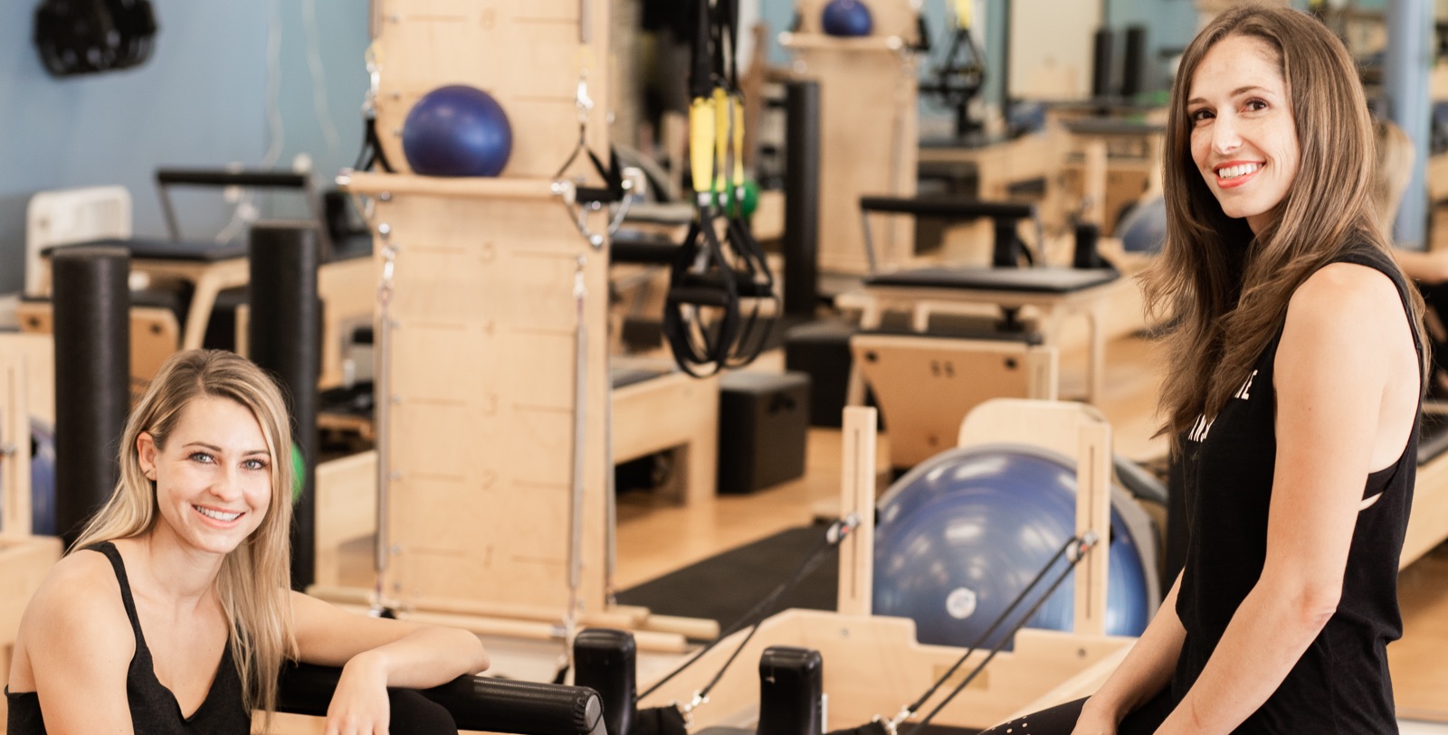 Two people smiling at Club Pilates